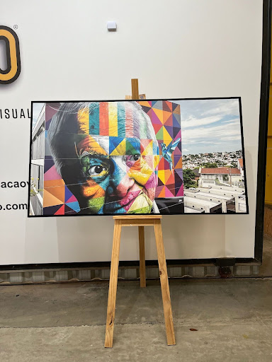 Quadro de senhor idoso exposto em um cavalete de madeira.